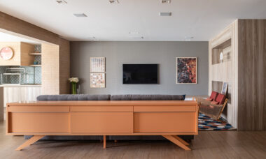 Na sala de estar conectada ao jantar, a arquiteta Marina Carvalho explorou as costas do sofá para instalar um buffet que organiza os itens utilizados pelos moradores |Fotos: Evelyn Müller