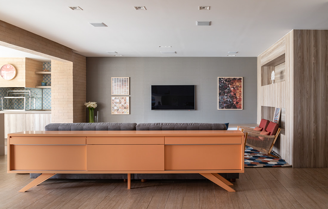 Na sala de estar conectada ao jantar, a arquiteta Marina Carvalho explorou as costas do sofá para instalar um buffet que organiza os itens utilizados pelos moradores |Fotos: Evelyn Müller 