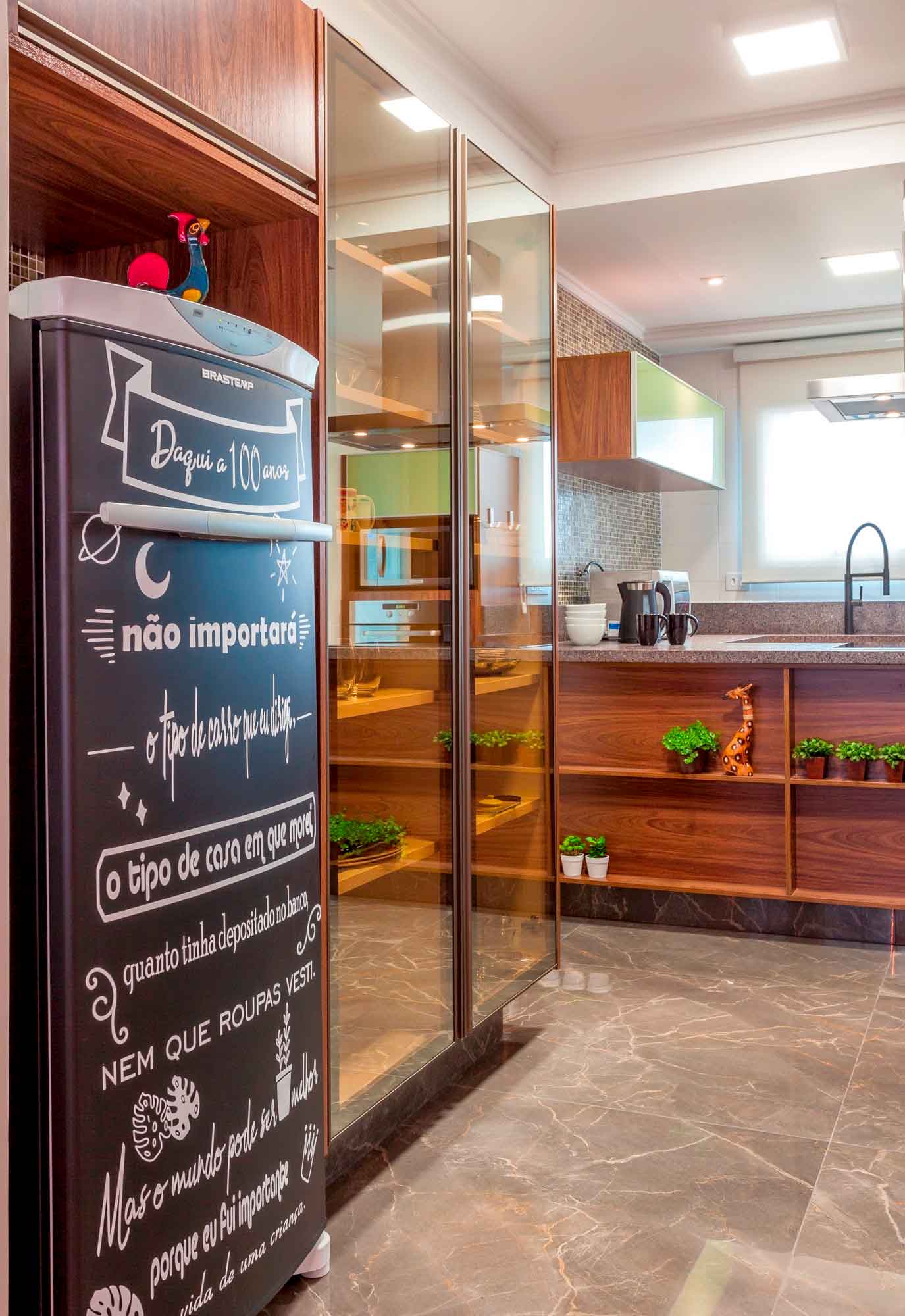 In the kitchen designed by architect Cristiane Schiavoni, the refrigerator wrapping allowed for adding a unique fridge for the residents. With a chalkboard feel, the door highlights positive messages | Photo: Carlos Piratininga